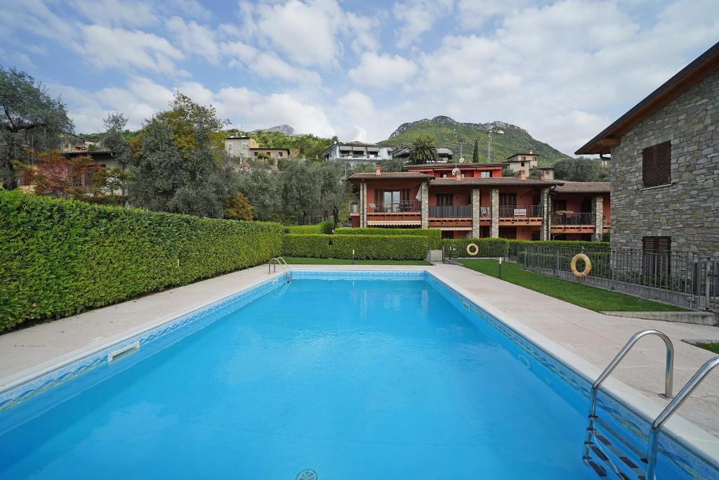 ein großer blauer Pool vor einem Haus in der Unterkunft Messaga in Toscolano-Maderno