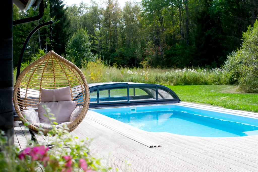 a wicker chair sitting on a deck next to a pool at HomeSweetHome in Üksnurme