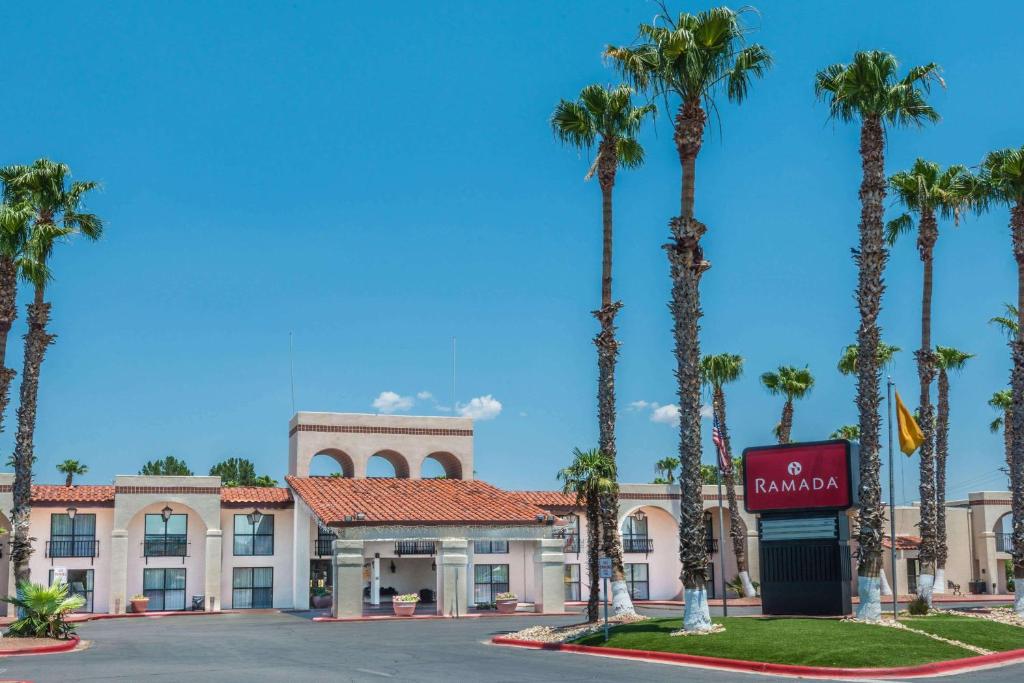 a hotel with palm trees in front of a building at Ramada by Wyndham Las Cruces Hotel & Conference Center in Las Cruces