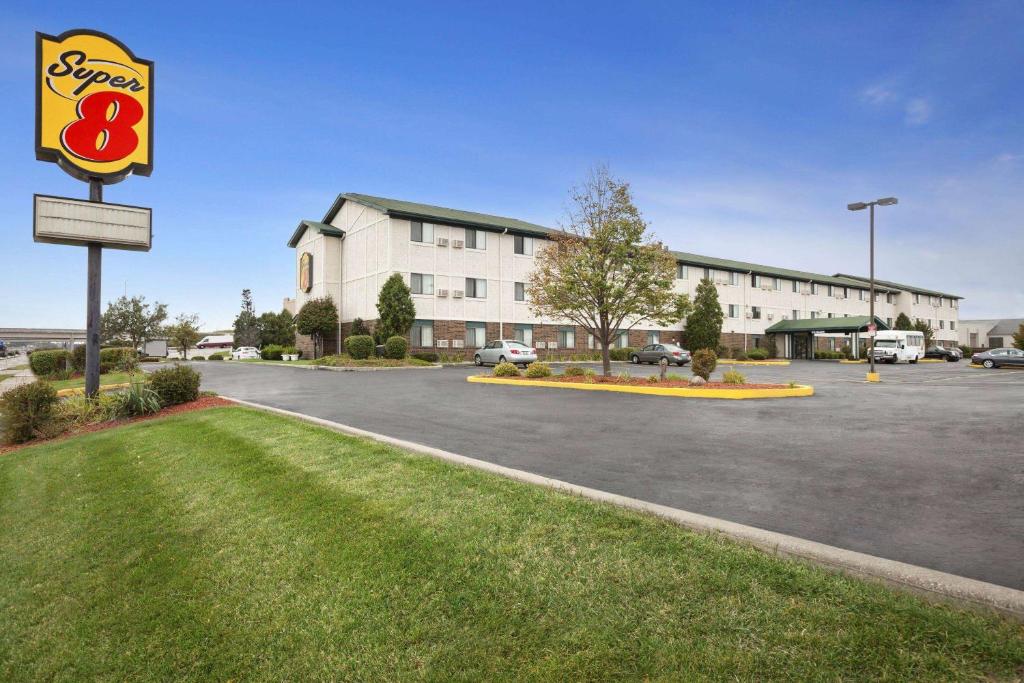 un panneau dans un parking en face d'un bâtiment dans l'établissement Super 8 by Wyndham Milwaukee Airport, à Milwaukee