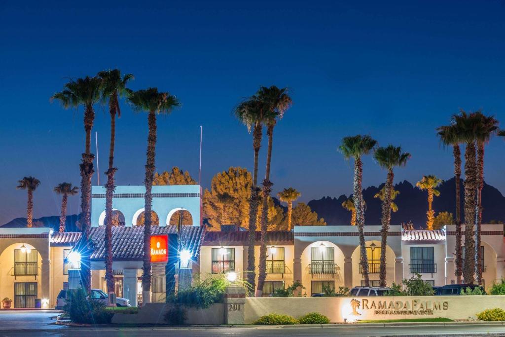 a building with palm trees in front of it at Ramada by Wyndham Las Cruces Hotel & Conference Center in Las Cruces