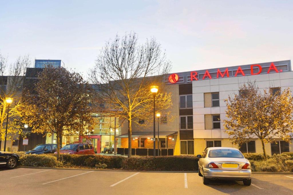 a car parked in a parking lot in front of a building at Ramada London North in Barnet