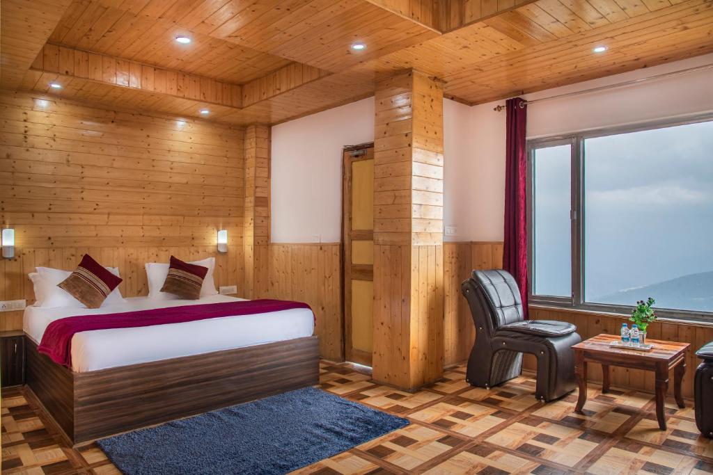 1 dormitorio con 1 cama, 1 silla y 1 ventana en Mountain View New Kufri en Cheog