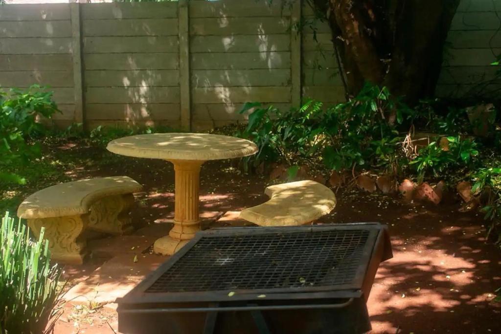 d'un jardin avec une table et un grill. dans l'établissement Cosy 3 bedroom cottage - 2034, à Kingsmead