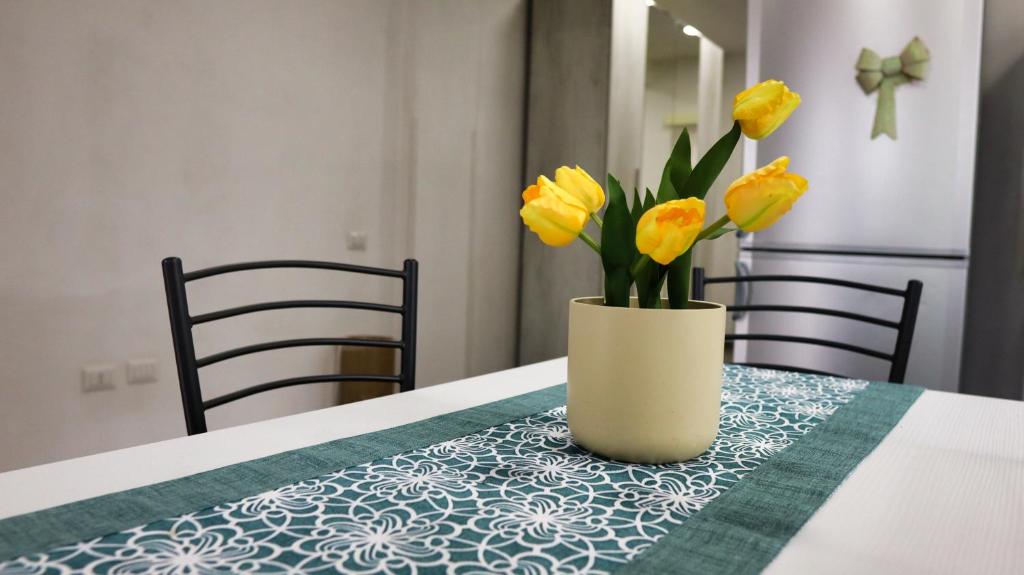 a vase with yellow flowers sitting on a table at La Casa al Porto in Salerno