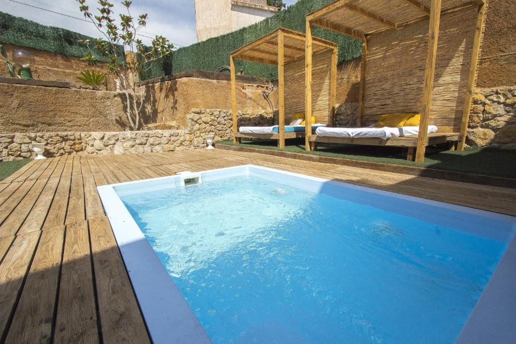 una piscina con terraza de madera y un dormitorio en Catalunya Casas Splendid Sanctuary with private pool 15km to Sitges!, en Olèrdola