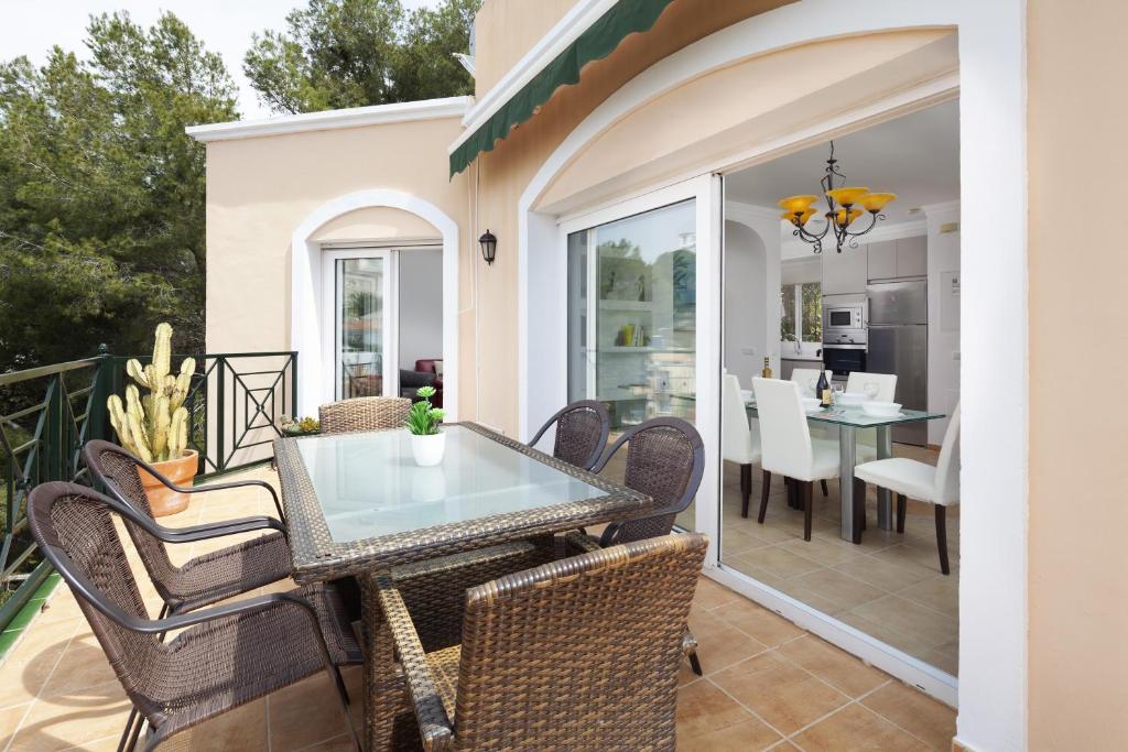 patio ze stołem i krzesłami na balkonie w obiekcie Villa Miramar Burriana Beach 10 pax w mieście Nerja