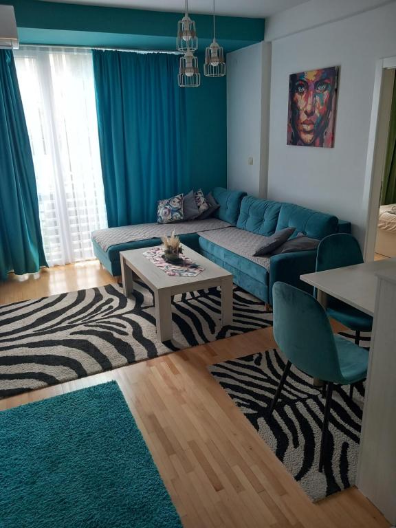 sala de estar con sofá azul y mesa en City Apartment, en Ohrid