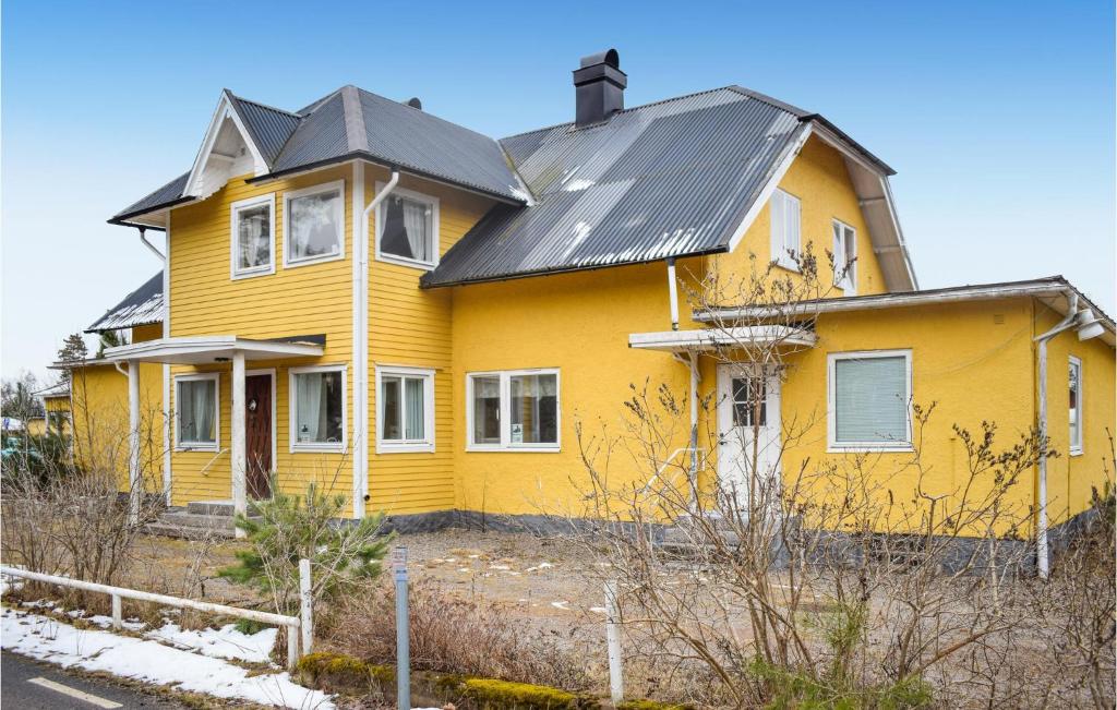 een geel huis met een zwart dak bij 5 Bedroom Lovely Apartment In Mlilla in Målilla