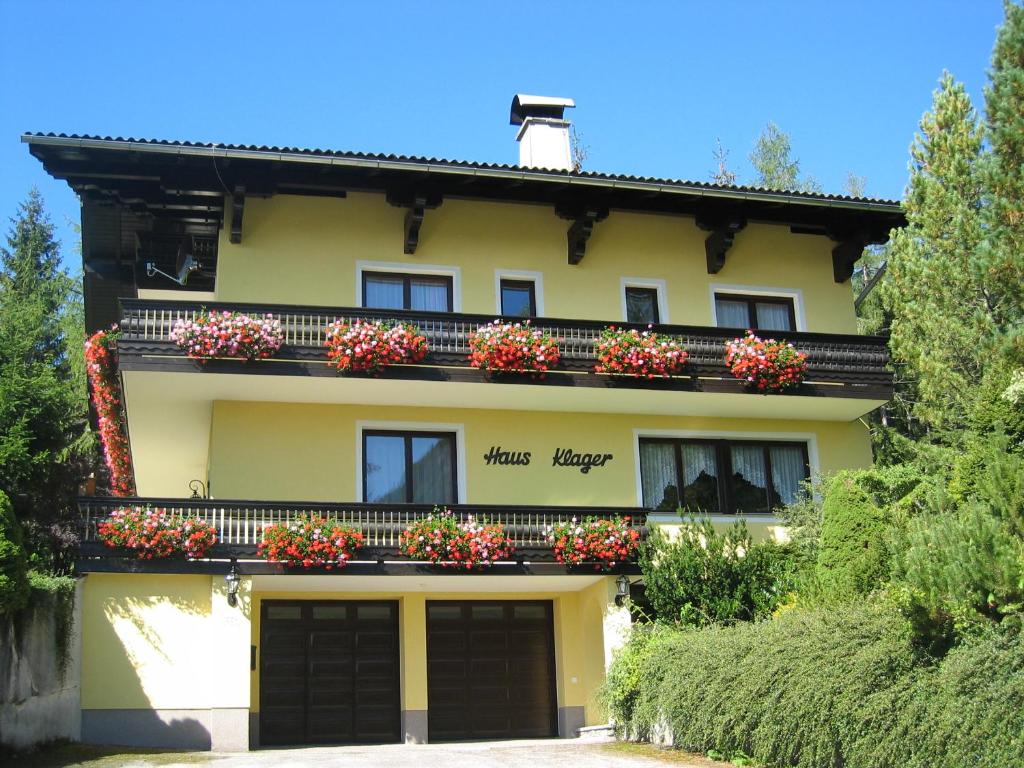 a yellow building with flower boxes on the balcony at Haus Klager in Ramsau am Dachstein