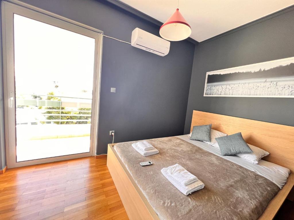 a bedroom with a large bed and a large window at Quiet and Cozy Apartment of New Psihiko No 6 in Athens