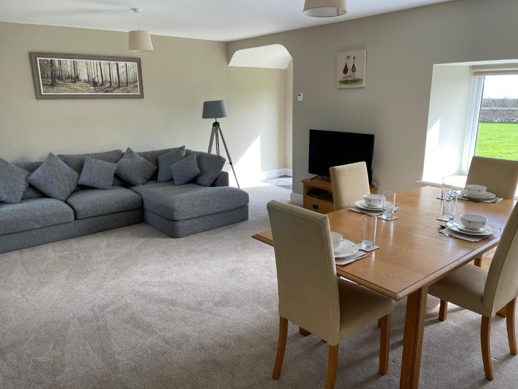 a living room with a table and a couch at Teviot Cottage 7 Fenton Hill Farm in Wooler