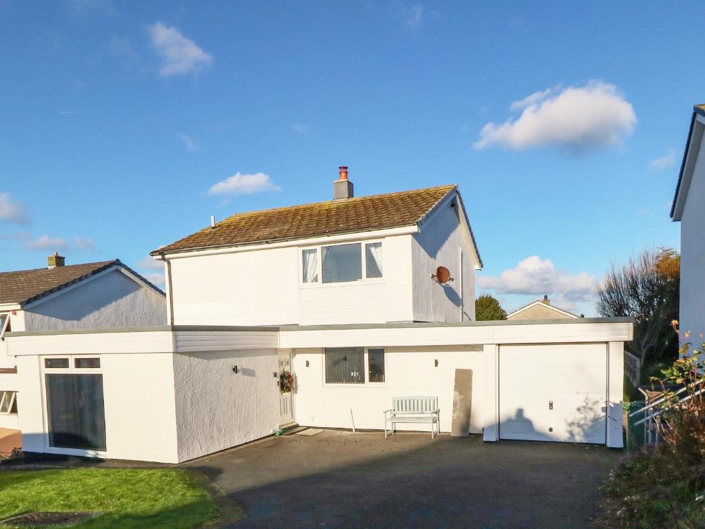 a white house with a garage at Artro in Cemaes Bay