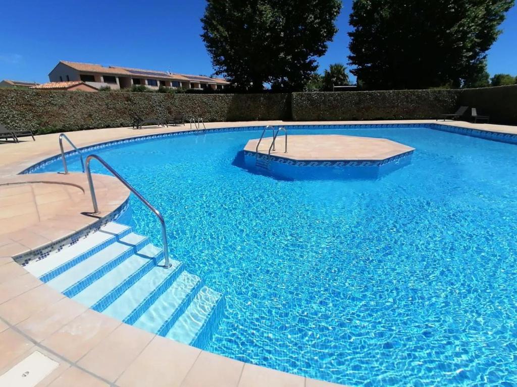 une grande piscine avec de l'eau bleue dans l'établissement LES REFLETS F5, à Saint-Cyprien