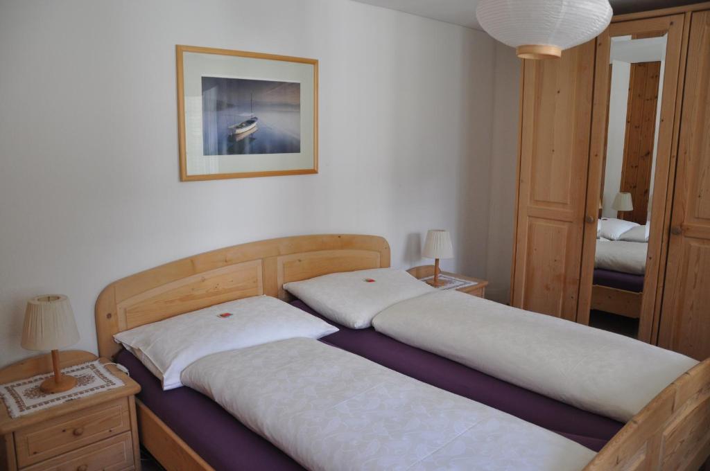 2 camas individuales en un dormitorio con 2 lámparas en FERIENWOHNUNGEN Chalet Hohturnen, en Grindelwald