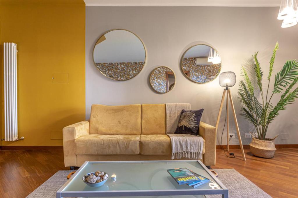 uma sala de estar com um sofá e dois espelhos em ElFaRo Kitty - Stylish Apartment Close to S. Peter em Roma