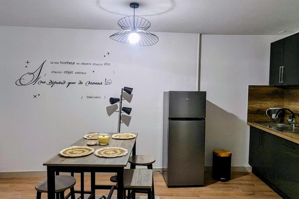 y cocina con mesa, sillas y nevera. en Zen Home - appartement jusqu'à 4 voyageurs, en Nantua