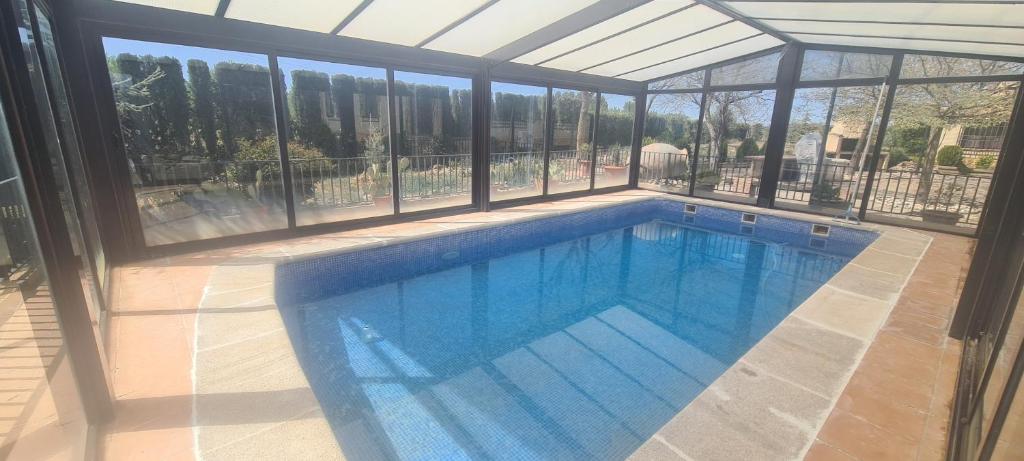 una gran piscina en una casa con ventanas en Finca Don Sancho, en Lillo