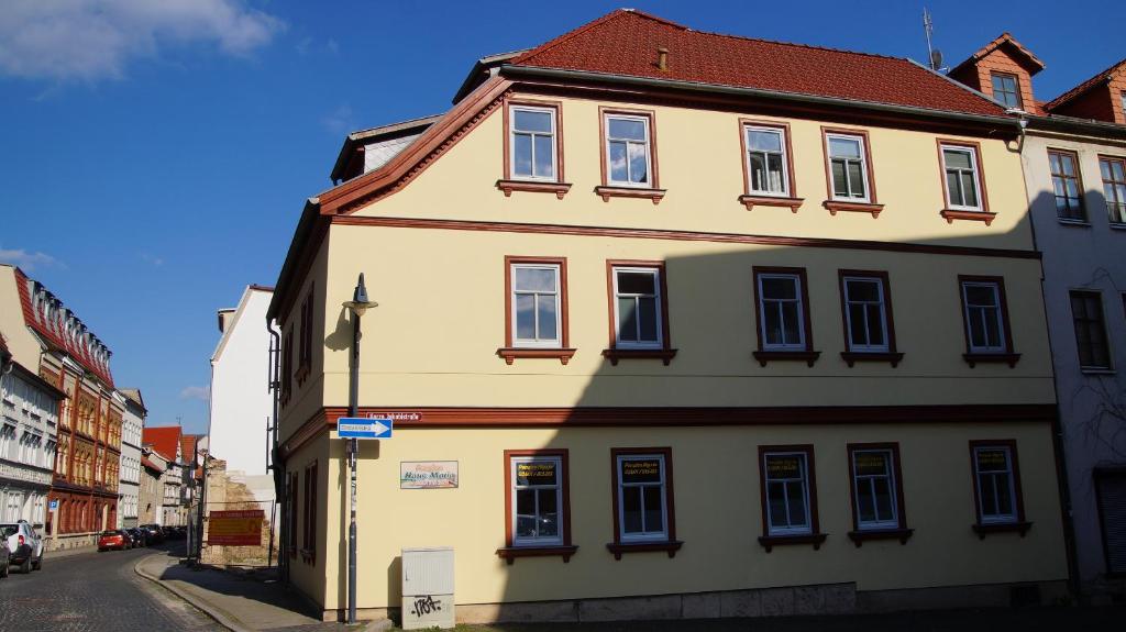 un grand bâtiment jaune sur le côté d'une rue dans l'établissement Ferienwohnung Haus Maria, à Mühlhausen
