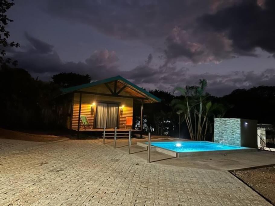 a small house with a swimming pool at night at Casa Cooper in Carrillo