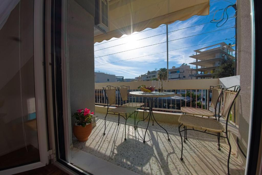 a balcony with chairs and a table on a balcony at Esperidon Luxury Apartment Glyfada in Athens