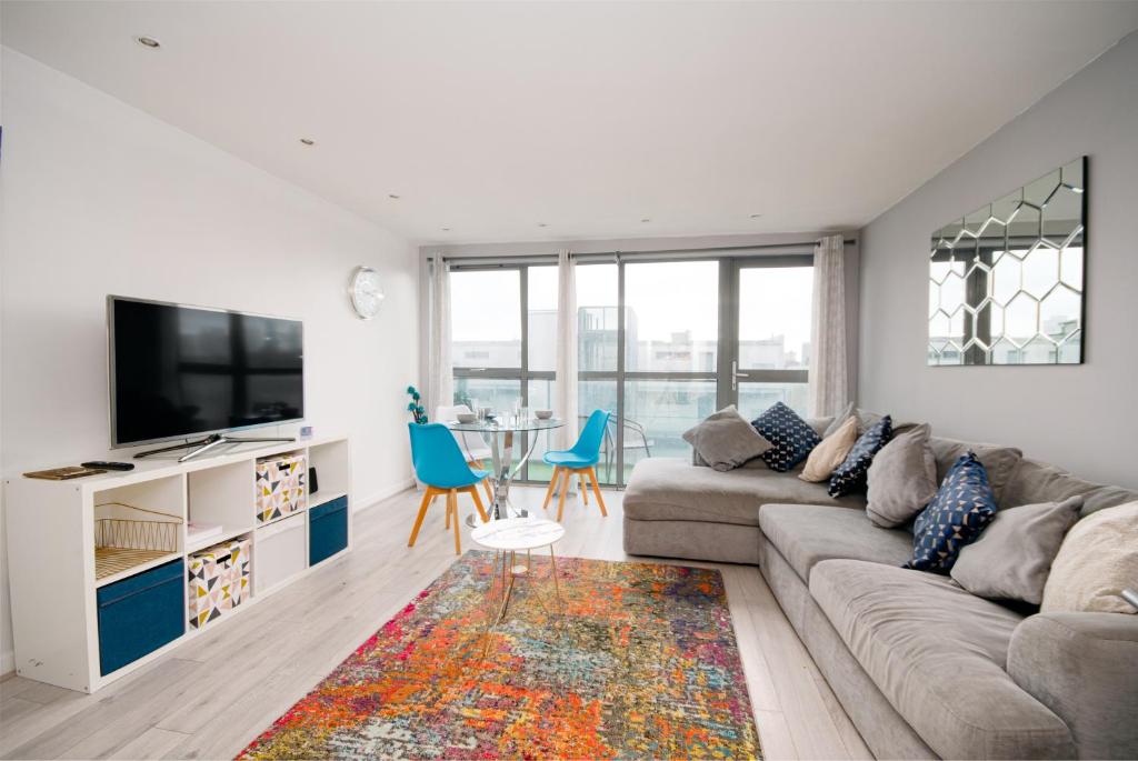 a living room with a couch and a tv and a table at Stylish Apartment Close to London Bridge in London