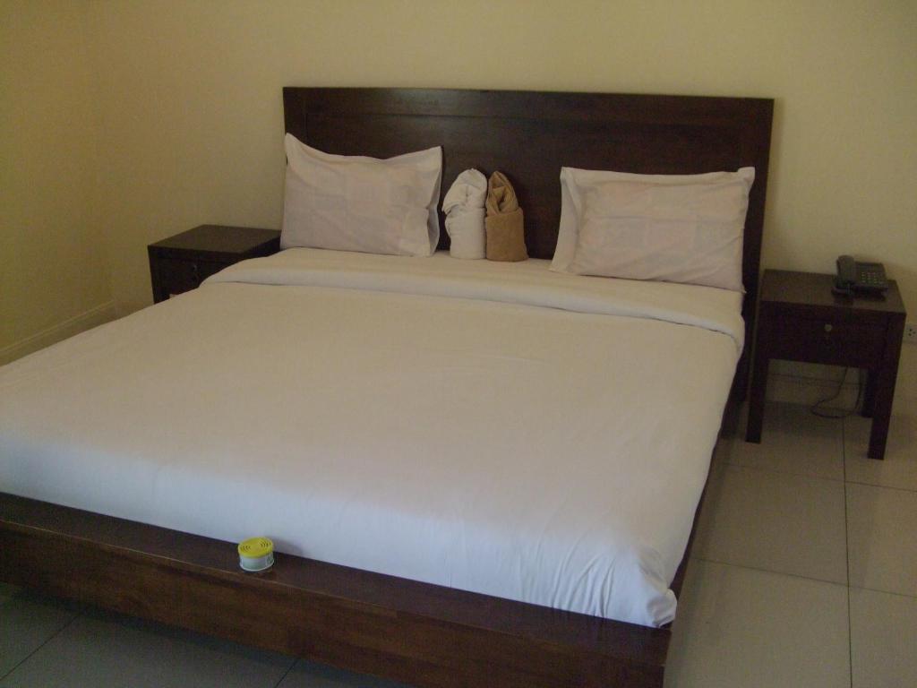 a bedroom with a large white bed with two night stands at Baan Kittima in Pattaya Central