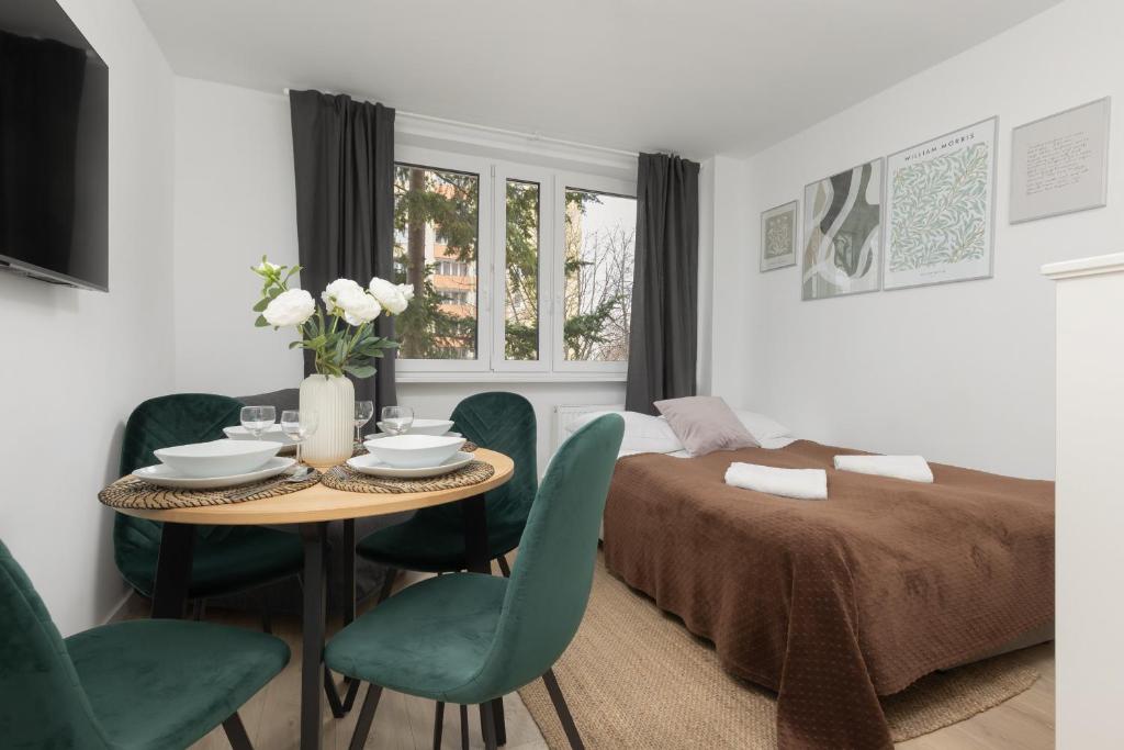 a bedroom with a bed and a table and chairs at Metro Bemowo Apartment by Renters in Warsaw