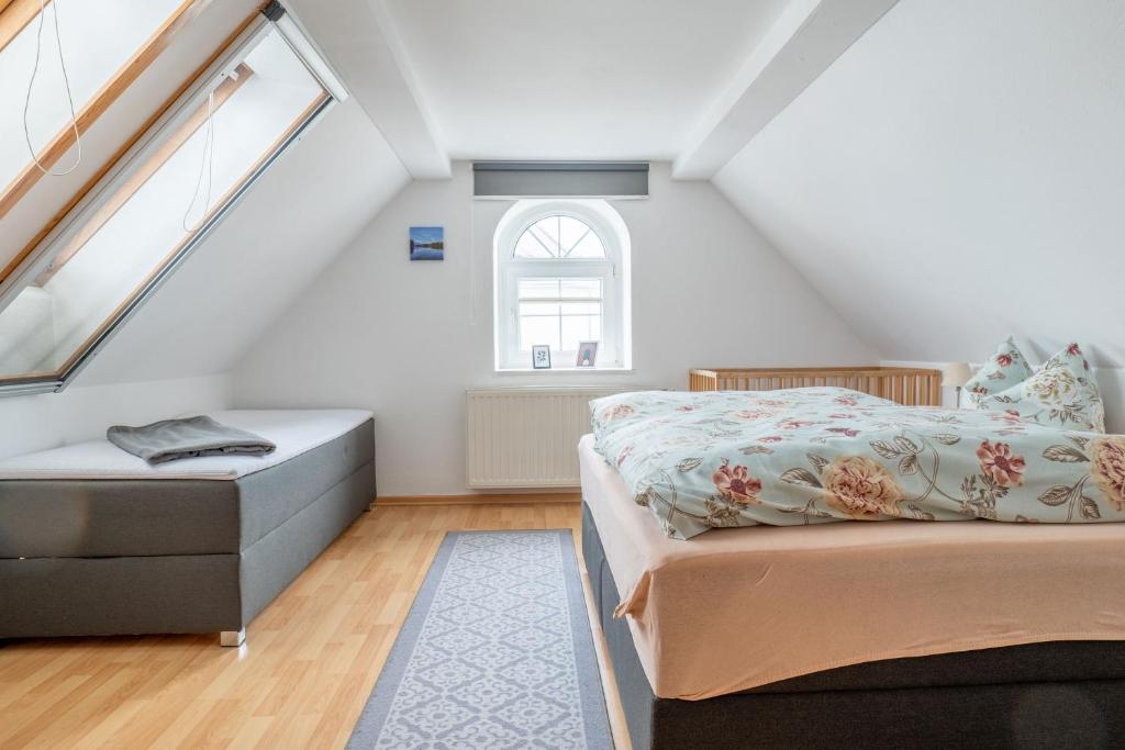 a attic bedroom with a bed and a window at Hof Türke in Moritzburg