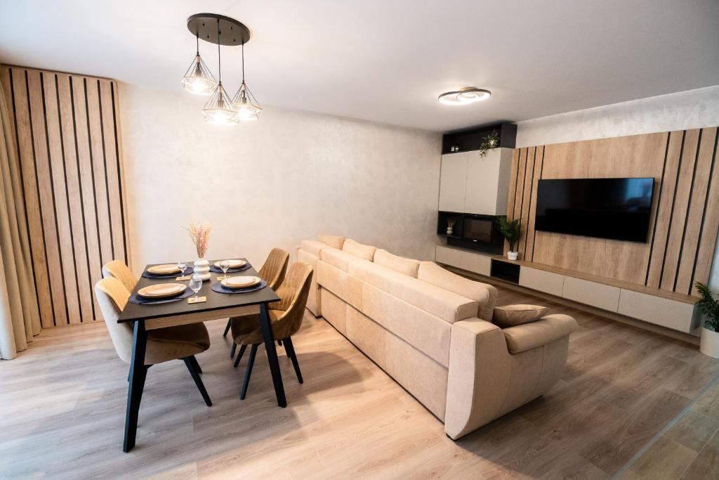 ein Wohnzimmer mit Sofa und Tisch in der Unterkunft Mountain Retreat-Modern 1BR w/ Fireplace & Parking in Braşov