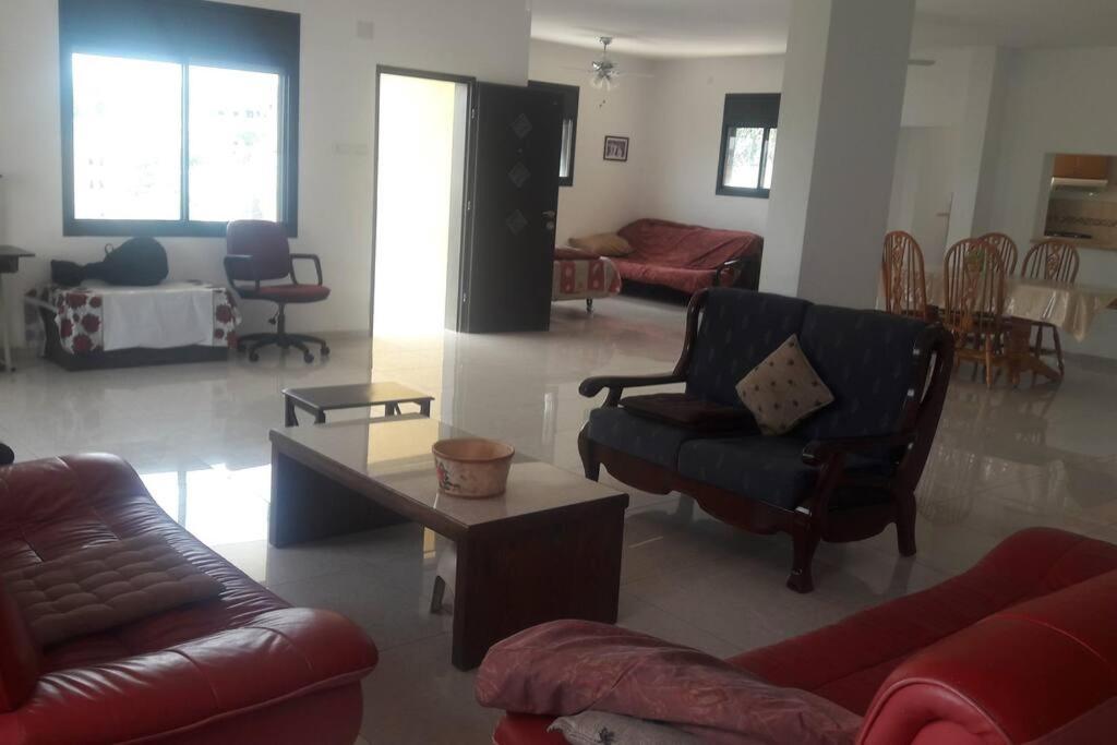 a living room with couches and a coffee table at nadera place in Shefar‘am