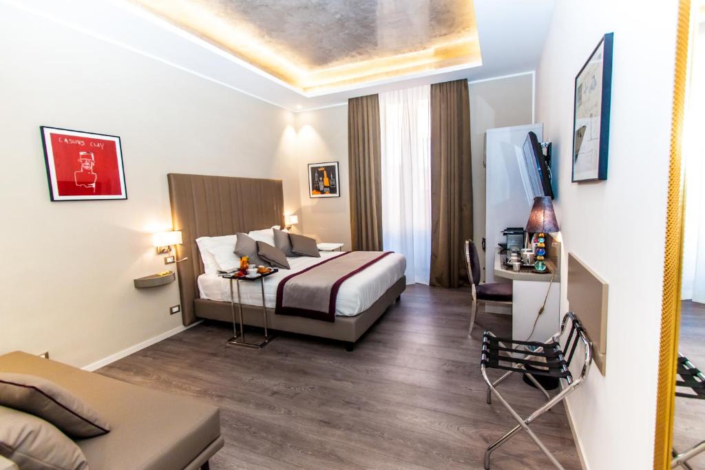 Habitación de hotel con cama, mesa y TV en Calisto Luxury Trastevere, en Roma