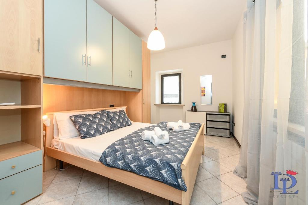 una camera da letto con un letto e due asciugamani di DesenzanoLoft Green lake court a Desenzano del Garda