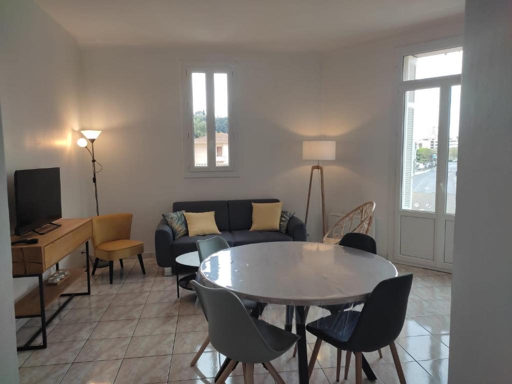 ein Wohnzimmer mit einem Tisch und einem Sofa in der Unterkunft F3 moderne proche marché et mer in Saint-Raphaël