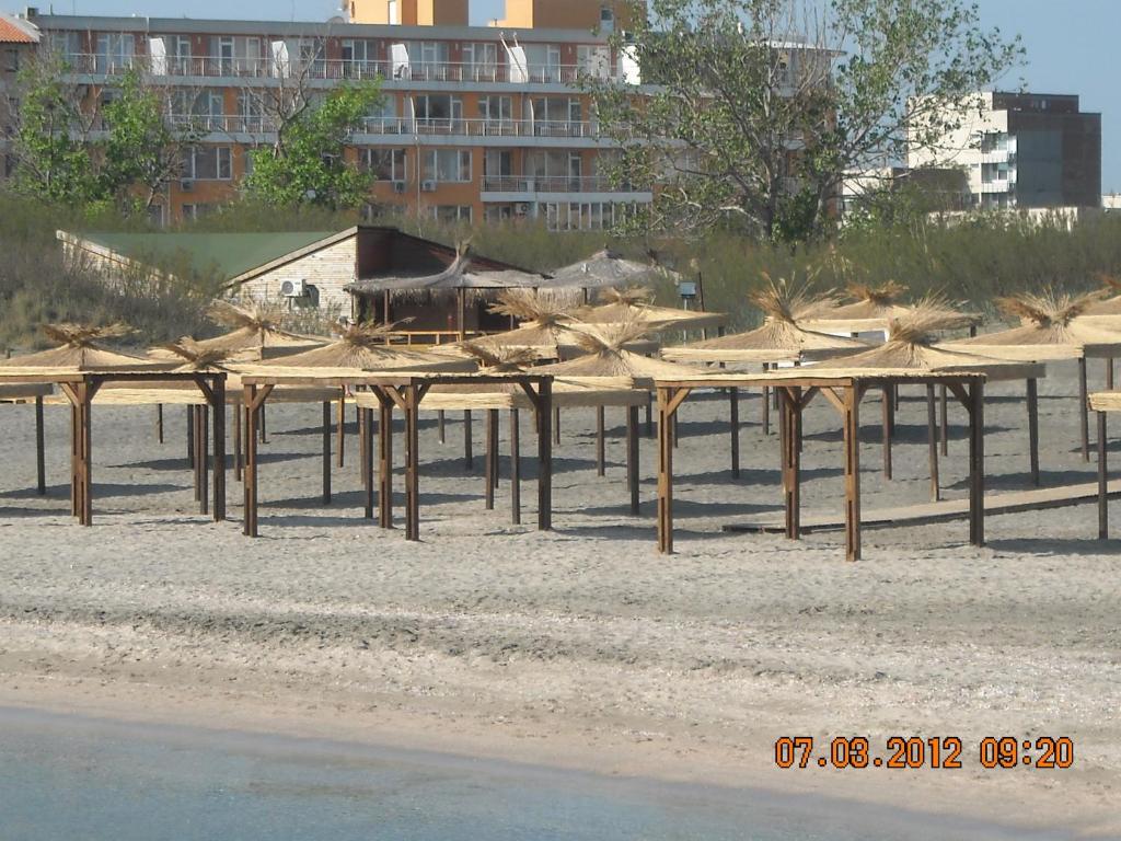 a group of wooden structures on the beach at Apartamenti Zhelezovi in Pomorie