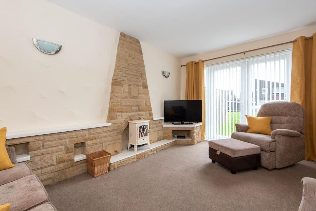 sala de estar con sillón y TV en Aysgarth Close en Newton Aycliffe