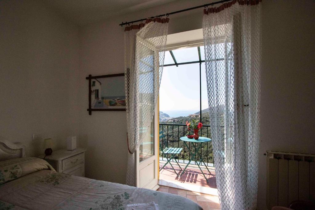 een slaapkamer met een raam met uitzicht op een balkon bij Le Case di Petra in Vignana