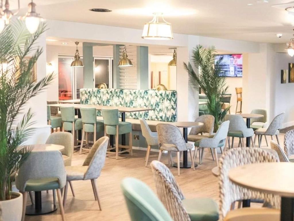 a restaurant with tables and chairs and a bar at LUXURY LODGE on edge of New Forest and 800m from sea ENTERTAINMENT and LEISURE PASSES INCLUDED in Milford on Sea