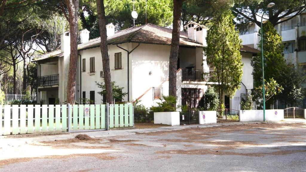 una casa bianca con una recinzione bianca e alberi di Villetta Marfisa a Lido di Spina