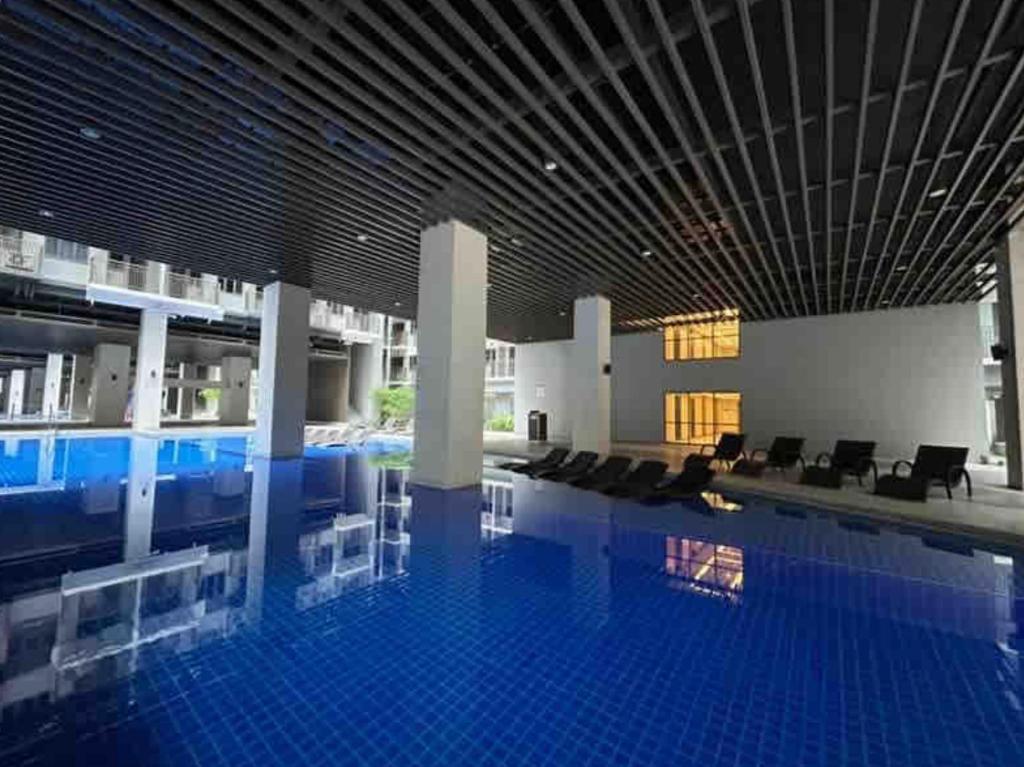 una grande piscina con sedie e un grande edificio di The Estrella Suite at the Mall of Asia Complex a Manila