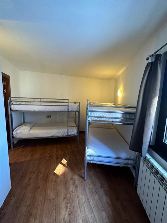 two bunk beds in a room with a wooden floor at Apartaments ENGAIT in Pas de la Casa