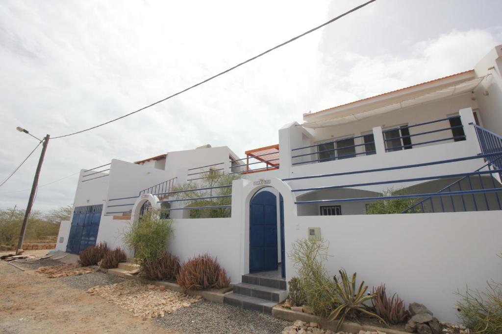 Biały dom z niebieskimi drzwiami w obiekcie Villa Sol e Mar - Vila do Maio - Ponta Preta w Vila do Maio