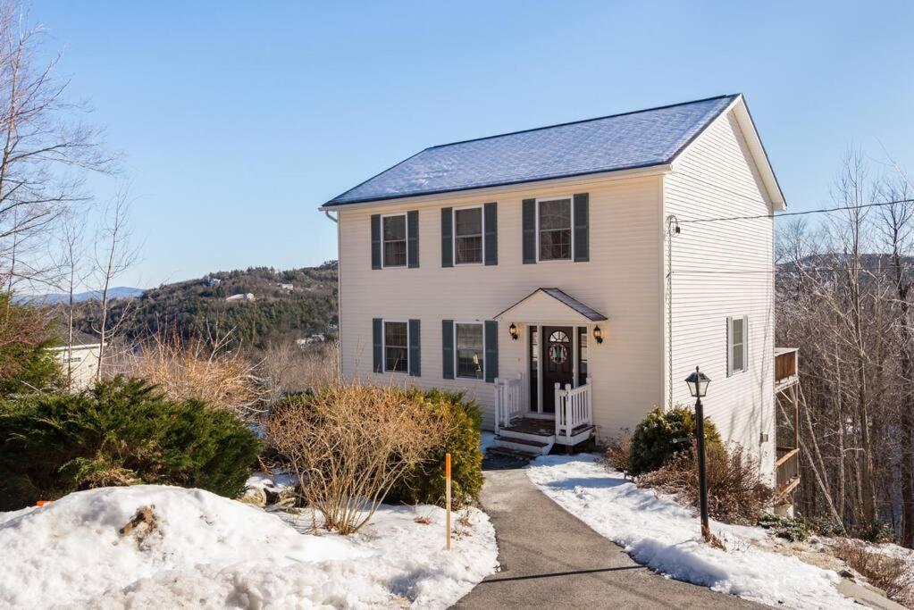 une maison blanche avec de la neige au sol dans l'établissement Fun & Fabulous Getaway, à Gilford