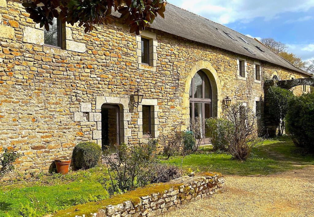 un ancien bâtiment en pierre avec un mur en pierre dans l'établissement Cottage de Keran, à Arradon