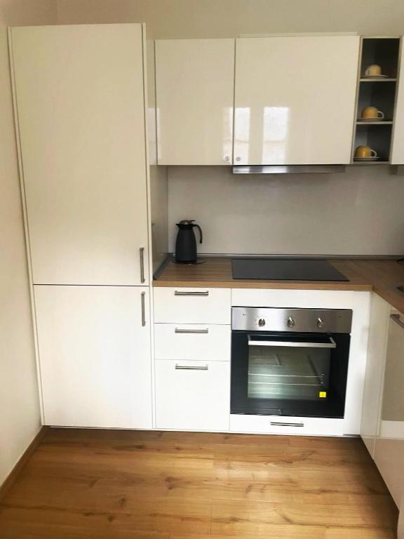 uma cozinha com armários brancos e um micro-ondas em Piccolo appartamento nel cuore di Trieste em Trieste