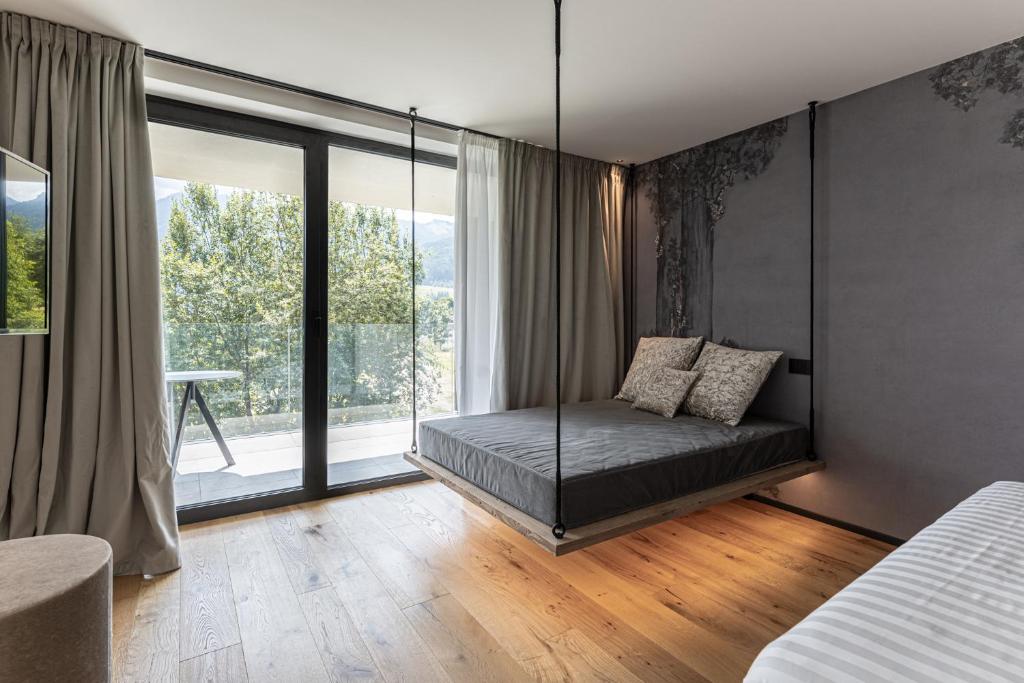 una camera con un letto e una grande finestra di Alpuris - Your Boutique Suite - Hotel B&B a Cavalese