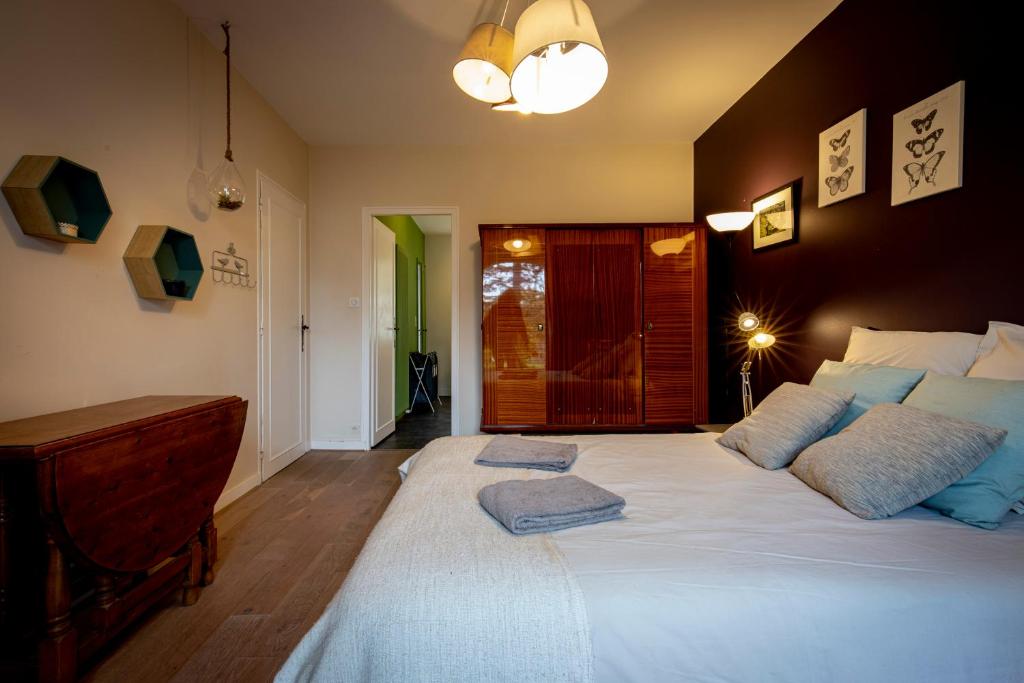 a bedroom with a large bed with two pillows on it at Maison 5 chambres #8pers #Stationnement gratuit in Cognac