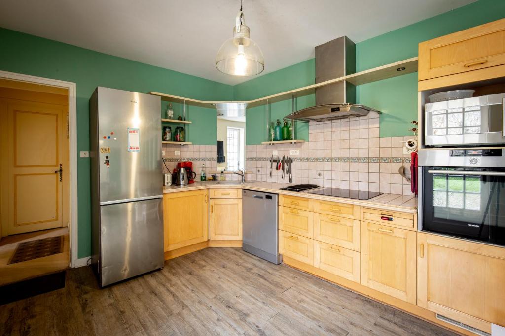 a kitchen with wooden cabinets and stainless steel appliances at Maison 5 chambres #8pers #Stationnement gratuit in Cognac