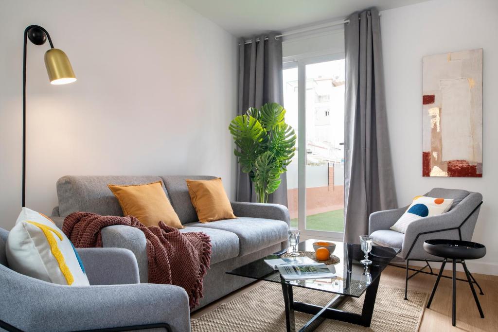 ein Wohnzimmer mit einem Sofa und 2 Stühlen in der Unterkunft Suites Maestranza - Santas Patronas by Magno Apartments in Sevilla