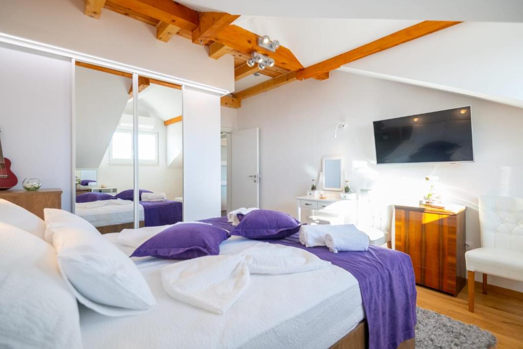 1 dormitorio con 1 cama grande con almohadas moradas y blancas en Chiefs Suite - Kriste en Dubrovnik